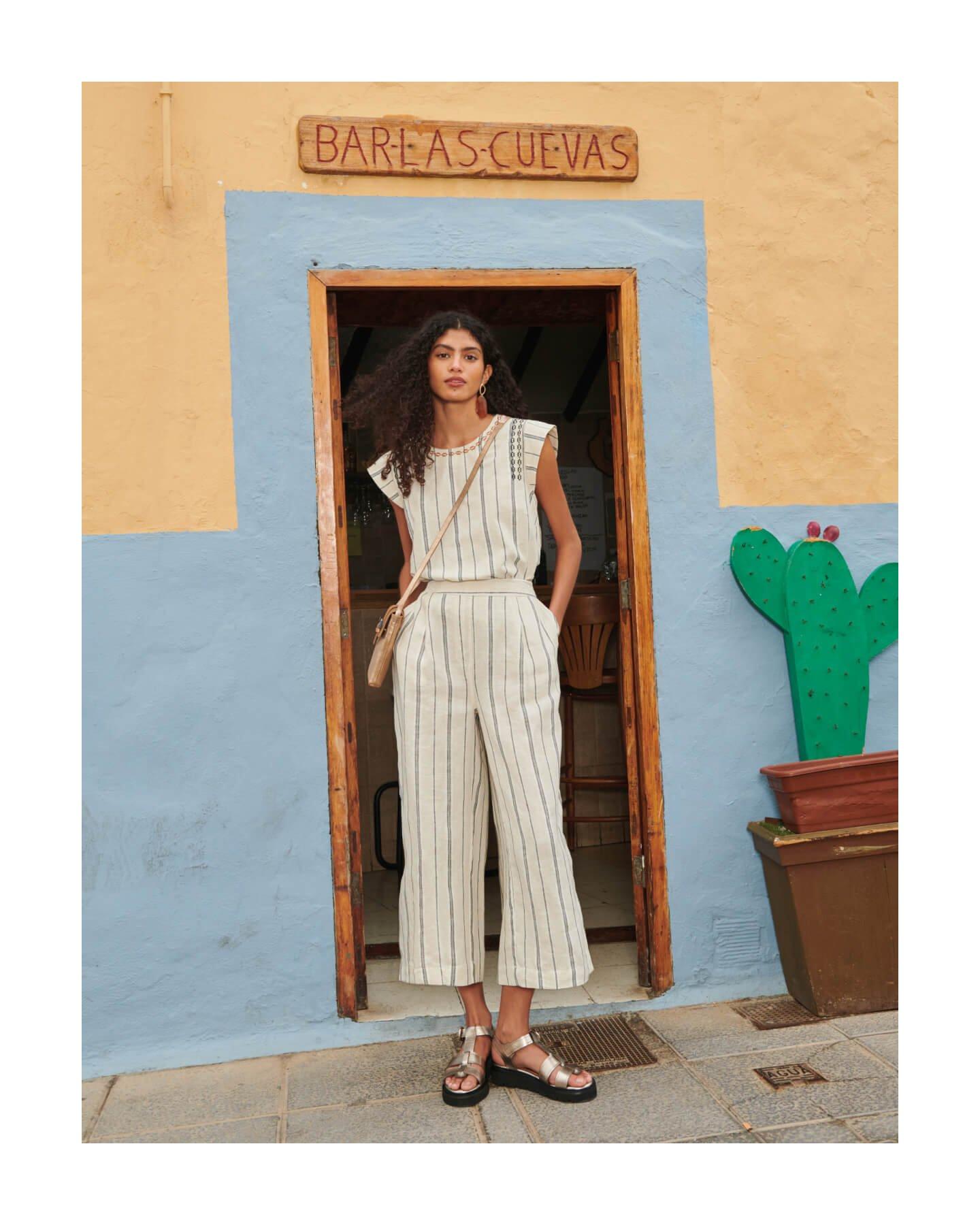 Woman wearing coordinated linen top and trousers standing in doorway